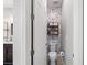 The powder room features a toilet, stylish wallpaper, and convenient shelving at 14238 59Th E Cir, Bradenton, FL 34211
