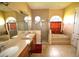 Bright bathroom with double vanity, walk-in shower, bathtub with tile surround, and abundant natural light at 15484 Alsask Cir, Port Charlotte, FL 33981