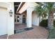 Exterior entrance featuring an arched entryway, a walkway, a palm tree and decorative light fixture at 15484 Alsask Cir, Port Charlotte, FL 33981