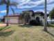 Charming single-Gathering home with a red tile roof, lush landscaping, and a spacious two-car garage at 15484 Alsask Cir, Port Charlotte, FL 33981