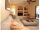 Relaxing living room featuring a comfortable sofa, built-in shelving, and screened lanai access at 15484 Alsask Cir, Port Charlotte, FL 33981