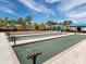 Well maintained outdoor bocce ball courts next to clubhouse lined by lush landscaping and seating area at 17019 Hampton Falls Ter, Lakewood Ranch, FL 34202