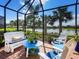 Relaxing screened patio with beautiful lake view, complete with comfortable seating and stylish blue accents at 17019 Hampton Falls Ter, Lakewood Ranch, FL 34202