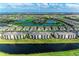 Scenic aerial view of a lakeside community featuring condos, golf course, and lush landscaping under a sunny blue sky at 18008 Gawthrop Dr # 308, Bradenton, FL 34211