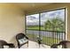 Enclosed balcony featuring wicker chairs and a picturesque view of the lake and golf course at 18008 Gawthrop Dr # 308, Bradenton, FL 34211