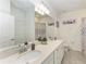 Bathroom featuring a double sink, a large mirror, and a bathtub with a shower curtain, creating a functional space at 18008 Gawthrop Dr # 308, Bradenton, FL 34211