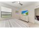 Bright bedroom with queen bed, flat screen TV, window with blinds, and views to other rooms at 18008 Gawthrop Dr # 308, Bradenton, FL 34211