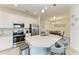 Modern kitchen featuring white cabinetry, stainless steel appliances, and a large island with seating, adjacent to the dining area at 18008 Gawthrop Dr # 308, Bradenton, FL 34211