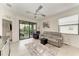 Bright living room with ceiling fan, sliding glass doors to balcony, and decorative rug at 18008 Gawthrop Dr # 308, Bradenton, FL 34211