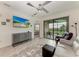 Comfortable living room with large TV, stylish cabinet, access to balcony, and view to another room at 18008 Gawthrop Dr # 308, Bradenton, FL 34211