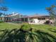 Backyard showcasing a lush lawn and a screened pool enclosure at 1838 Sandalwood Dr, Sarasota, FL 34231