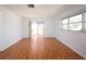 Bright bedroom with wood floors, a large window, and a sliding glass door to the backyard at 1838 Sandalwood Dr, Sarasota, FL 34231