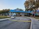 Community entrance with a covered drop-off area, blue roofing, and well-maintained landscaping at 1838 Sandalwood Dr, Sarasota, FL 34231