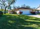 Charming home featuring a well-maintained lawn, mature trees, and a spacious two-car garage at 1838 Sandalwood Dr, Sarasota, FL 34231