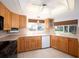 Well-lit kitchen features wood cabinets, tile backsplash, and window views to the backyard at 1838 Sandalwood Dr, Sarasota, FL 34231