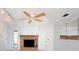 A bright living room showcasing a traditional stone fireplace, neutral paint, and a ceiling fan at 1838 Sandalwood Dr, Sarasota, FL 34231