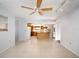 Living room adjacent to kitchen features tile floors, neutral walls, a ceiling fan, and access to the pool area at 1838 Sandalwood Dr, Sarasota, FL 34231