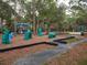 Community playground with walking path and playground equipment with several trees at 1838 Sandalwood Dr, Sarasota, FL 34231