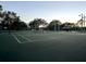 Community tennis courts with green surface, surrounding fence, and a shaded pavilion at 1838 Sandalwood Dr, Sarasota, FL 34231