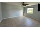 The primary bedroom is bright and airy with tile flooring, a ceiling fan, and a sunny window with a neighborhood view at 2105 Pueblo Cir # V2, Sarasota, FL 34231