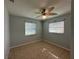 Bright bedroom features neutral walls, tile flooring, ceiling fan, and two windows providing natural light at 2105 Pueblo Cir # V2, Sarasota, FL 34231
