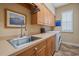 Functional laundry room with ample counter space, cabinets, and a stainless steel sink at 22642 Morning Glory Cir, Bradenton, FL 34202