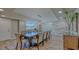 Bright dining room featuring a large wood table, seating for ten, stone accent wall, and light wood flooring at 2301 Gulf Of Mexico Dr # 33N, Longboat Key, FL 34228