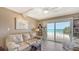 Bright living room with a beige couch and ocean view from the sliding glass door onto the balcony at 2301 Gulf Of Mexico Dr # 33N, Longboat Key, FL 34228