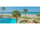 Beautiful pool area with lounge chairs overlooking a white sand beach and the ocean at 2301 Gulf Of Mexico Dr # 33N, Longboat Key, FL 34228