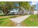 Outdoor bocce ball court with grassy lawn, beautiful trees, benches, and community building in the background at 2326 Canal Dr # G25, Bradenton, FL 34207