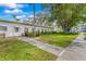 Well manicured front lawn featuring mature trees and a sidewalk leading to the building entrance at 2326 Canal Dr # G25, Bradenton, FL 34207