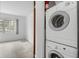 A laundry area with a stacked washer and dryer set, located near a bedroom at 2326 Canal Dr # G25, Bradenton, FL 34207