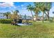 Outdoor picnic area with grill, tables, benches, grassy lawn, and community building in the background at 2326 Canal Dr # G25, Bradenton, FL 34207