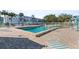 Community pool with cool blue water and brick paver deck surrounded by chairs and a building at 2326 Canal Dr # G25, Bradenton, FL 34207