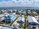 Aerial view of the neighborhood showing houses with pools and ocean views in the distance at 2408 Avenue B, Bradenton Beach, FL 34217