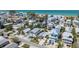 An aerial view of the cozy coastal home surrounded by mature landscaping, set amongst other quaint beach homes at 2408 Avenue B, Bradenton Beach, FL 34217