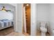 Bathroom with a stone shower and a toilet, adjacent to a bedroom with ceiling fan at 2408 Avenue B, Bradenton Beach, FL 34217