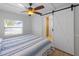 Bedroom featuring ceiling fan, bathroom access, neutral color palette, and natural light at 2408 Avenue B, Bradenton Beach, FL 34217