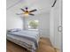 Well-lit bedroom featuring wood-look flooring, ceiling fan, and a comfortable bed at 2408 Avenue B, Bradenton Beach, FL 34217