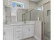 Bathroom showcases double vanity with white cabinets, modern tile flooring, and walk-in shower with glass door at 3 Boswell St, North Port, FL 34288