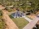 Aerial view of home with dark roof in an area with native trees; the lot is landscaped with a long drive at 302 Liden St, Port Charlotte, FL 33953