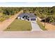Aerial view of a modern home with well-maintained landscaping and surrounded by trees under a bright sky at 302 Liden St, Port Charlotte, FL 33953