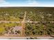 An aerial view of a house with a dark roof surrounded by dense vegetation at 302 Liden St, Port Charlotte, FL 33953