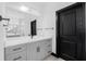 Bathroom featuring modern grey vanity with black hardware and large mirror at 302 Liden St, Port Charlotte, FL 33953