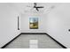 Bedroom with gray tile flooring, modern ceiling fan, and views of the outdoors at 302 Liden St, Port Charlotte, FL 33953