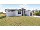 Modern home with a clean white exterior, black accents, and a well-maintained lawn under a sunny sky at 302 Liden St, Port Charlotte, FL 33953