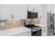 Close up of kitchen with backsplash, stainless appliances, white cabinets, and quartz countertops at 302 Liden St, Port Charlotte, FL 33953
