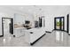 Well-lit kitchen features white cabinets, stainless steel appliances, and island with bar seating at 302 Liden St, Port Charlotte, FL 33953