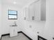 Bright laundry room features white cabinets, stainless sink, and modern fixtures at 302 Liden St, Port Charlotte, FL 33953