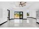 Spacious living area features tile flooring, a tray ceiling with fan, access to the backyard, and recessed wall cutouts at 302 Liden St, Port Charlotte, FL 33953